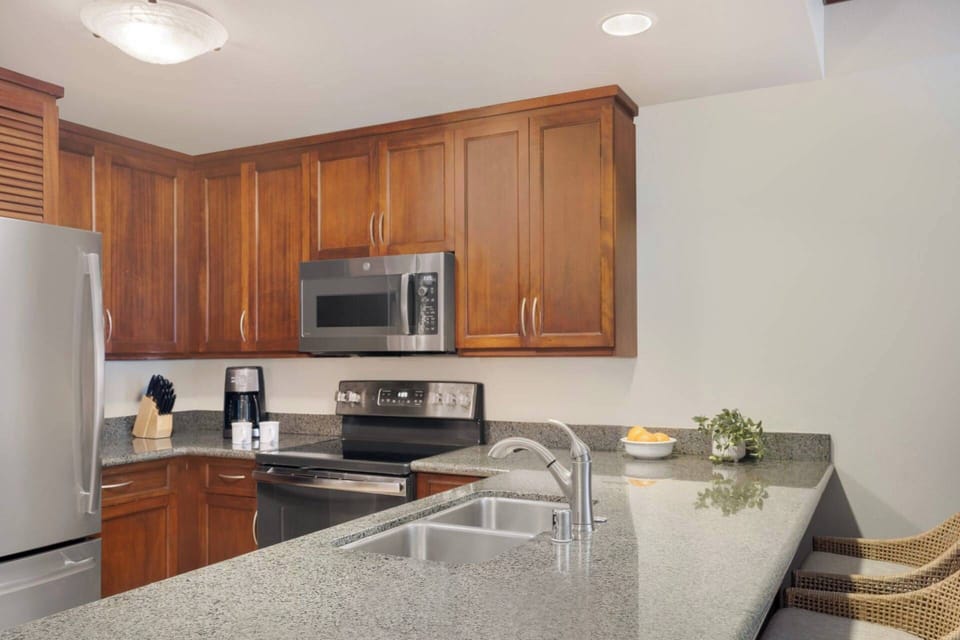 Full Kitchen with dishes, glasses, utensils, and extra counter seating.