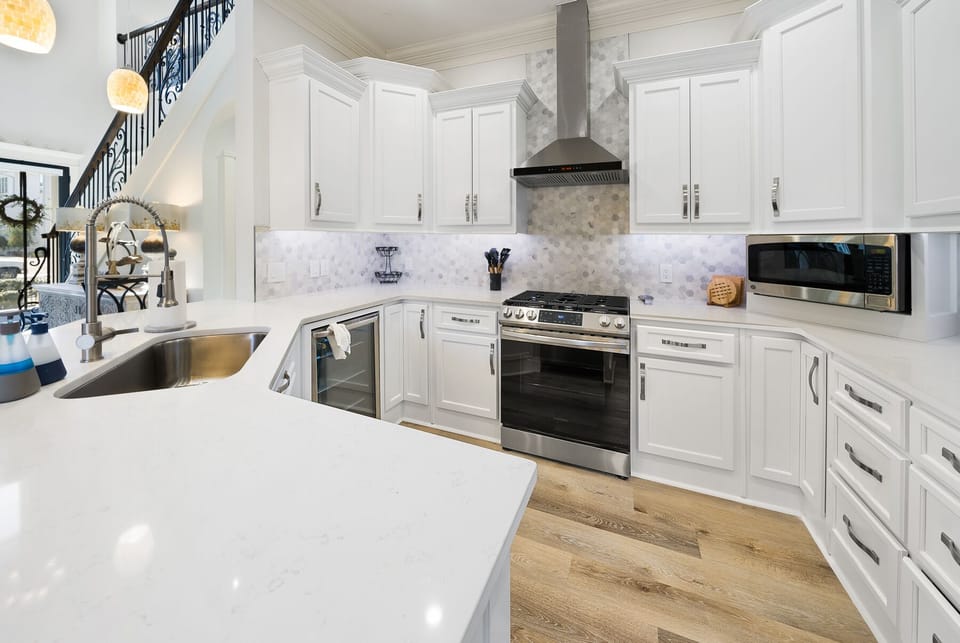 You'll love creating culinary masterpieces in this stunning chef's kitchen, featuring pristine white cabinetry, marble countertops, and premium stainless steel appliances.