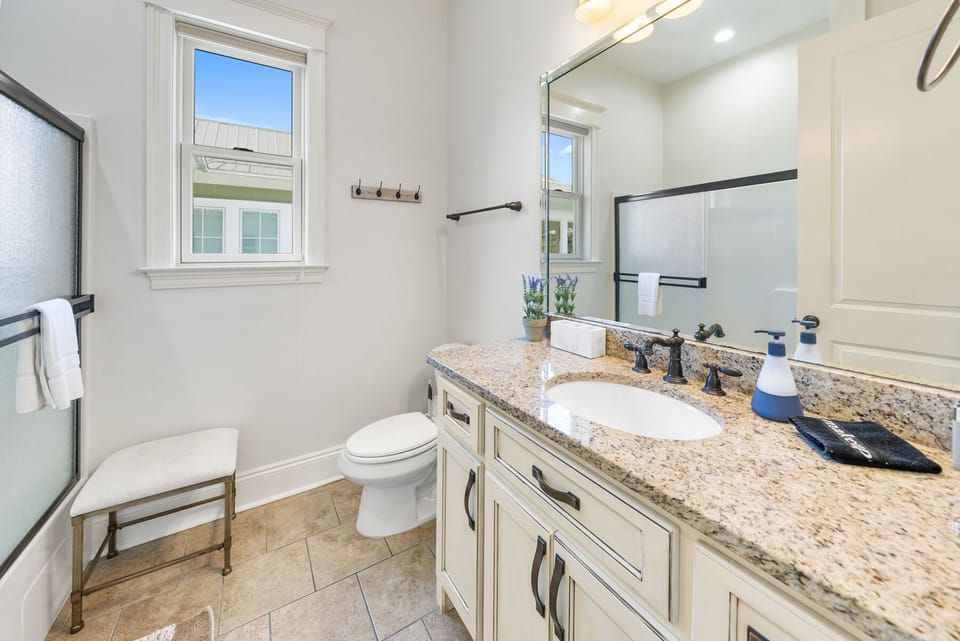 Refresh in your elegant bathroom featuring granite countertops, premium fixtures, and natural light streaming through classic windows.