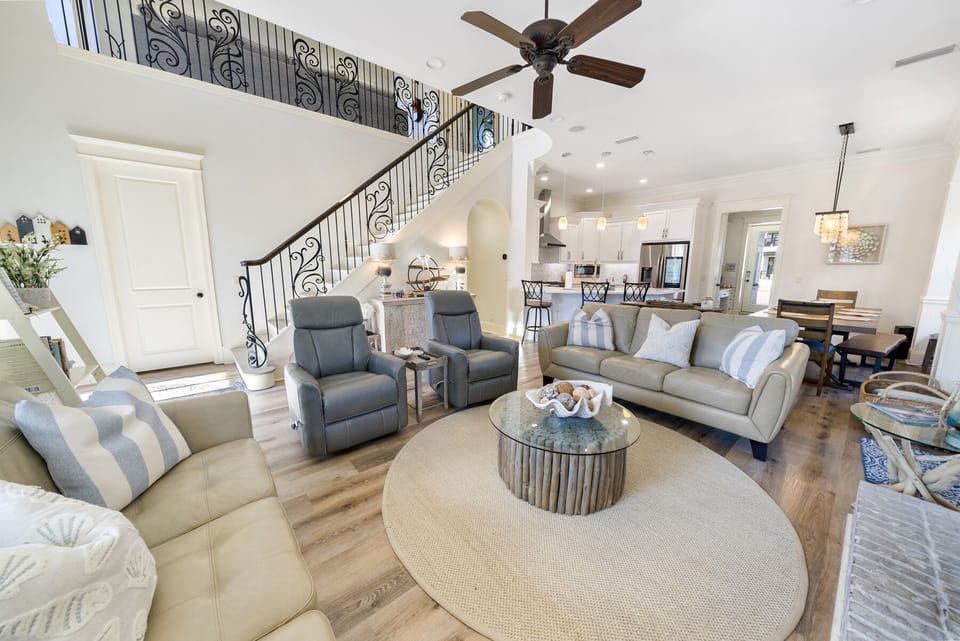 Sink into plush leather seating in this bright, open-concept living space where coastal charm meets modern elegance for your perfect getaway.