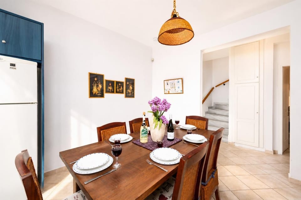 Open-plan living room with sofa, dining area, kitchen, ornamental fireplace, A/C, WiFi internet, and satellite TV