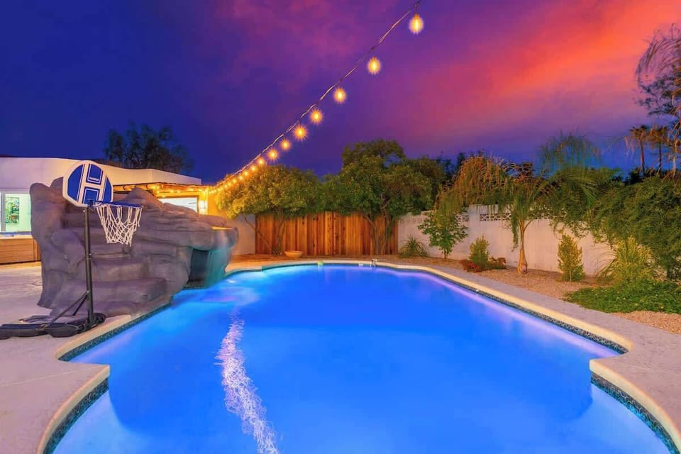 Picture yourself unwinding in this glowing private pool at dusk, surrounded by lush greenery and warm string lights, perfect for evening swims or poolside relaxation.