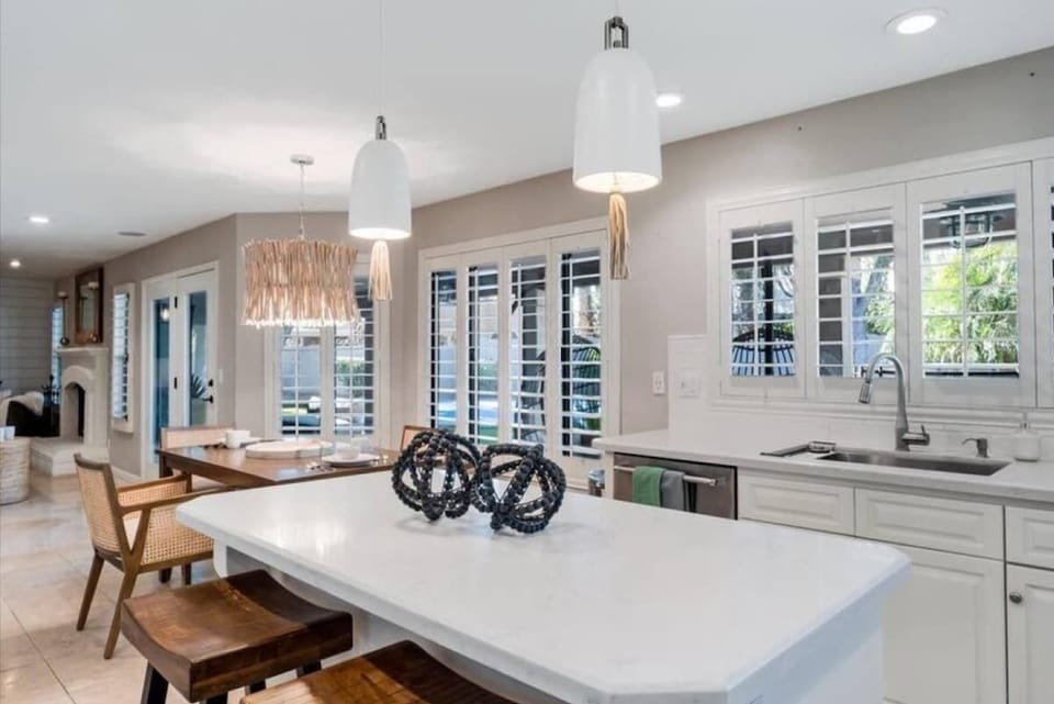 Your spacious chef's kitchen awaits with a stunning marble island, elegant lighting, and serene garden views—perfect for cooking, gathering, and making memories.