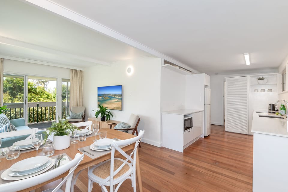 Open-plan living, dining and kitchen flow to the balcony after Little Cove days.