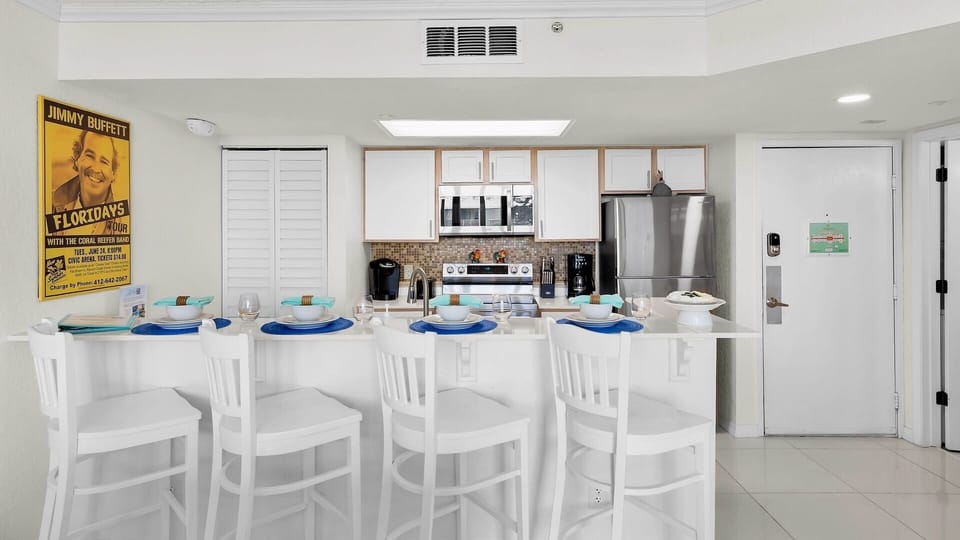 Step into your bright, fully equipped kitchen where morning coffee and family meals come together. White cabinetry, stainless appliances, and a welcoming breakfast bar with seating for five make this space perfect for your getaway.