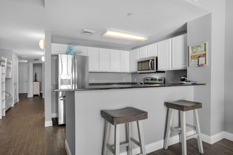 Dining Area - Gather in this stylish dining area with seating for four, perfect for savoring home-cooked meals while soaking in the stunning beach views! Includes 2 bar stools at the kitchen bar for extra seating.