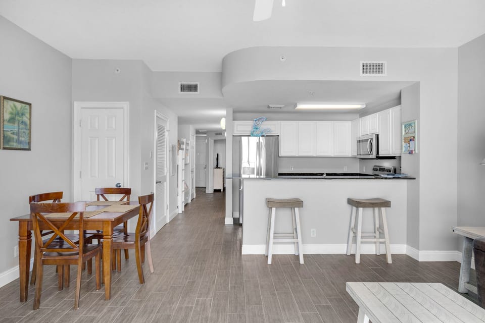 Dining Area - Gather in this stylish dining area with seating for four, perfect for savoring home-cooked meals while soaking in the stunning beach views! Includes 2 bar stools at the kitchen bar for extra seating.