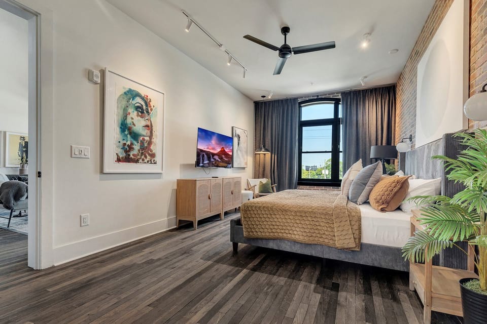 Light-filled bedroom w/ statement window, artwork & calming neutral tones