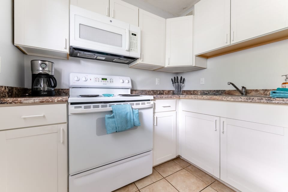 Fully equipped kitchen with full-size appliances and coffee maker.