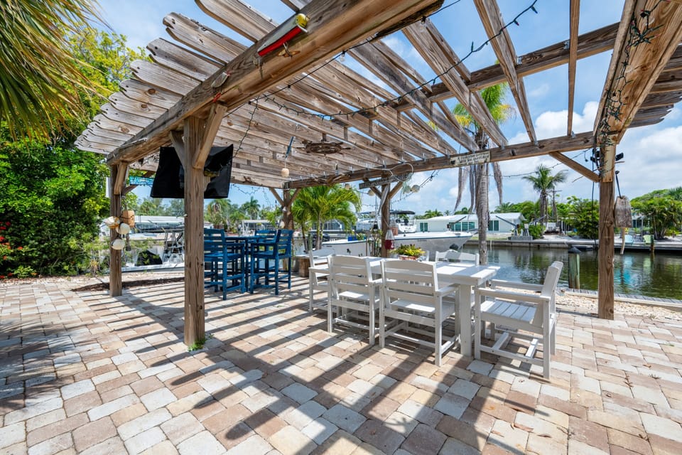 Enjoy outdoor meals beneath the shared waterfront pergola overlooking the canal.