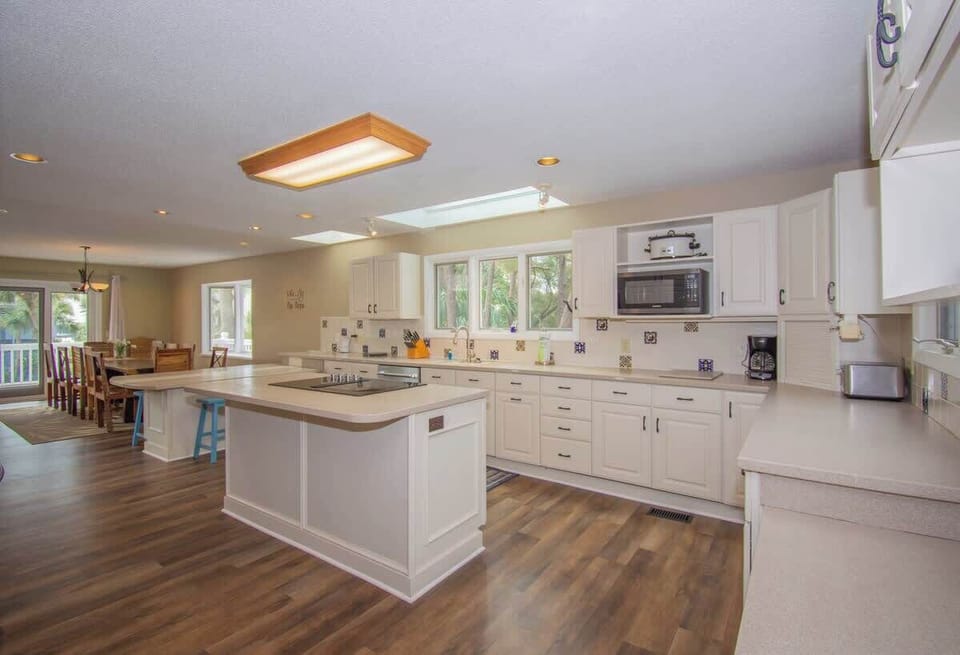 Kitchen with Updated Appliances, Including a Wall Oven and Two Islands, One With a Built-In Cooktop.