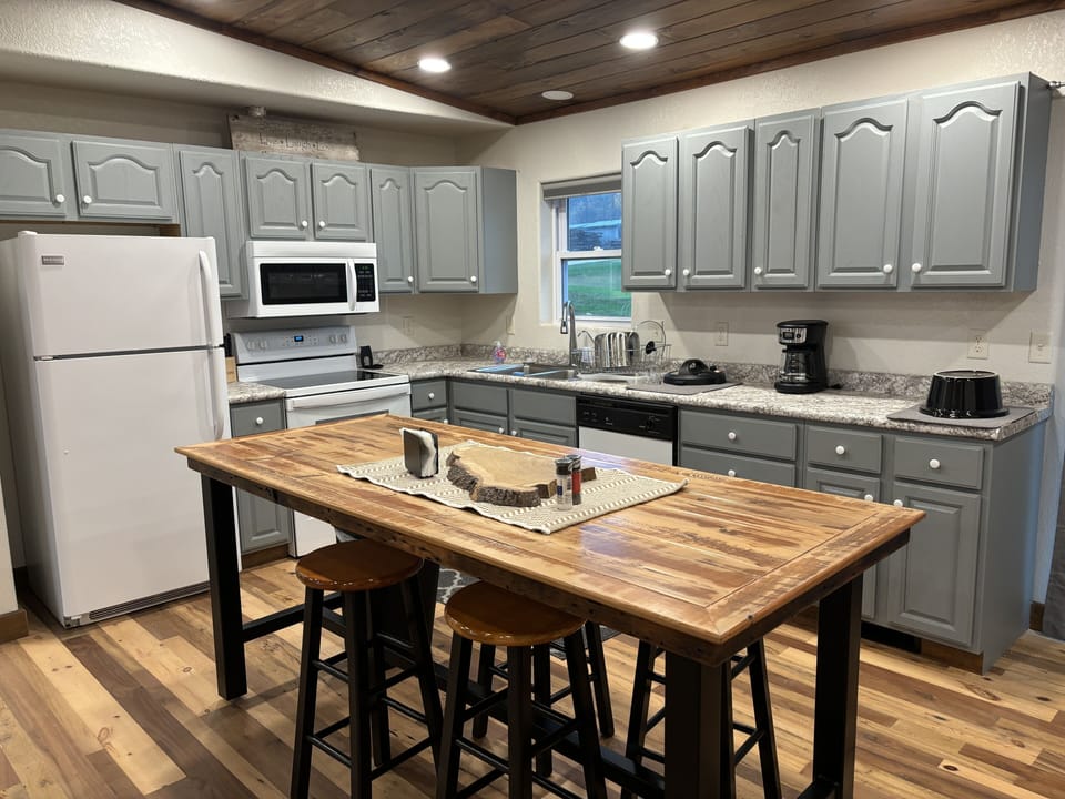 Kitchen cabinets are stocked with small appliances, cookware and tableware.