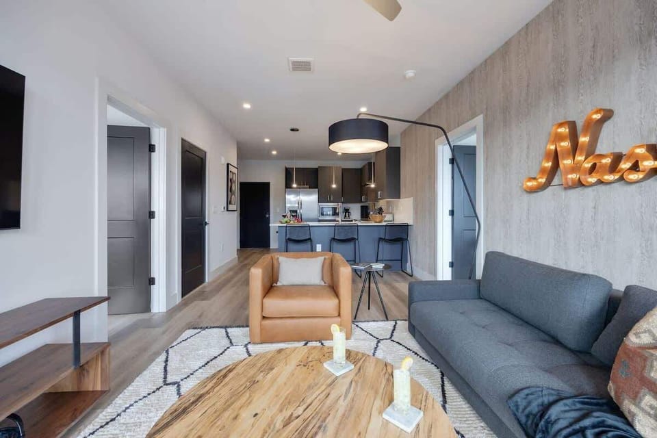 Bright living room with comfortable seating, smart TV, designer decor, and access to the private patio.