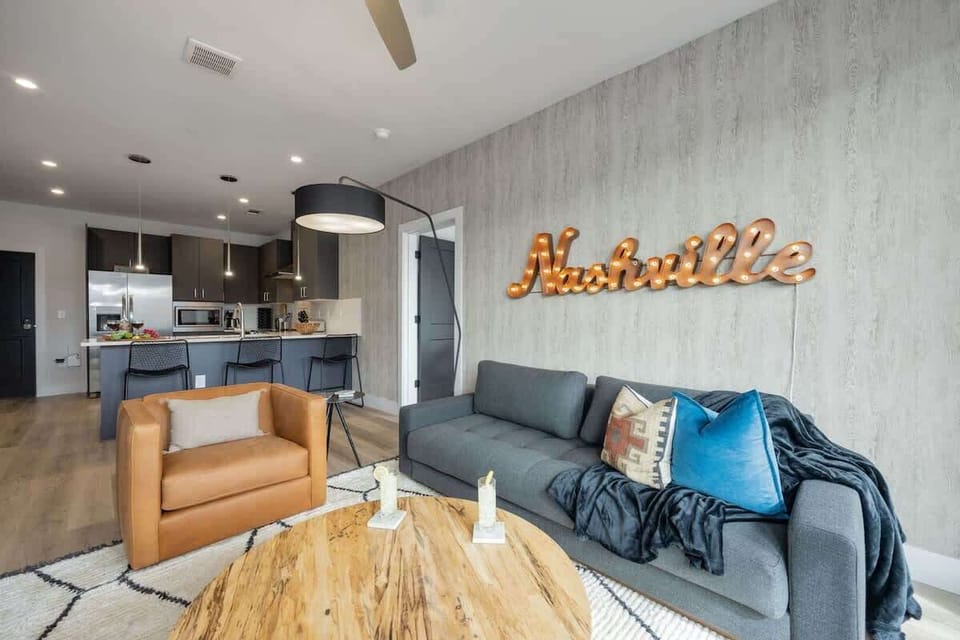 Bright living room with comfortable seating, smart TV, designer decor, and access to the private patio.