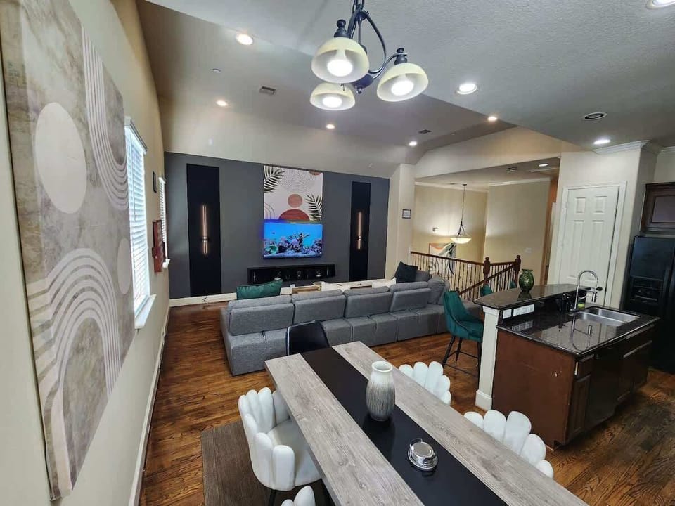 Open living area with cozy sofa, dining view, and wall-mounted TV screen
