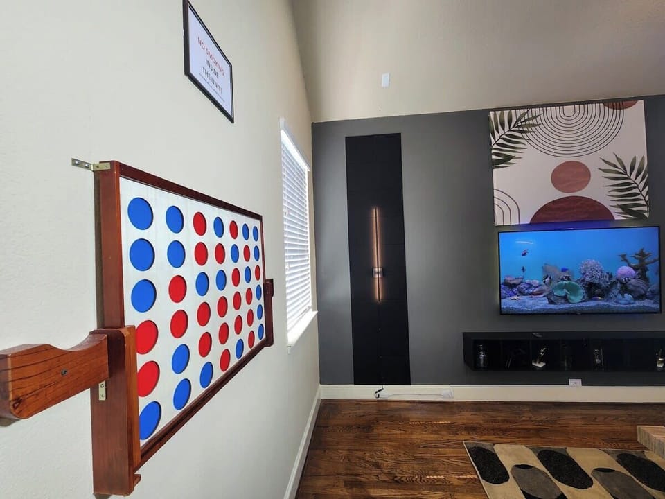 Experience the awe-inspiring atmosphere of our living room, where modern artistry takes center stage and leaves a lasting impression on all who enter. "Playful and fun: Enjoy a unique twist with a life-size Connect Four game mounted on the wall.