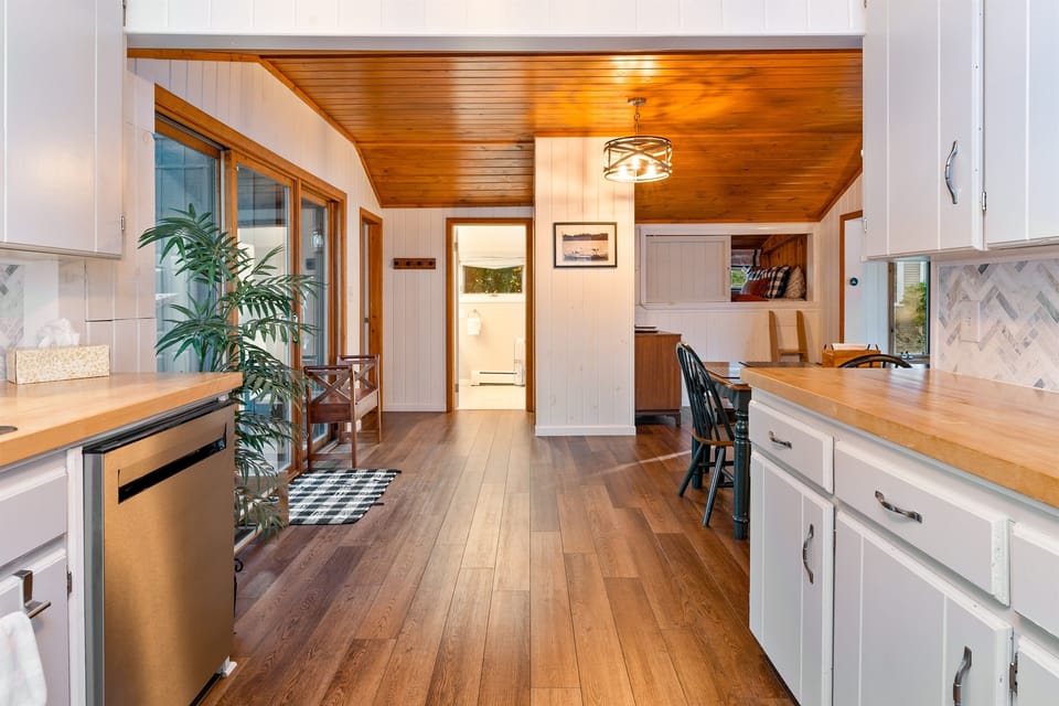 Kitchen flows seamlessly into the dining area, the powder room, and the queen bedroom