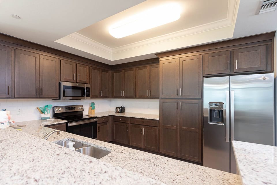 Prepare meals in this kitchen with elegant cabinetry, stainless appliances, and spacious countertops