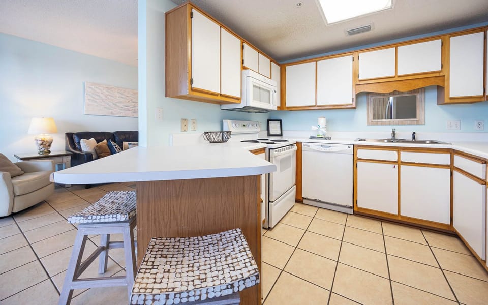 Prepare meals in this cozy kitchen, featuring ample counter space and a breakfast bar for coffee or casual dining