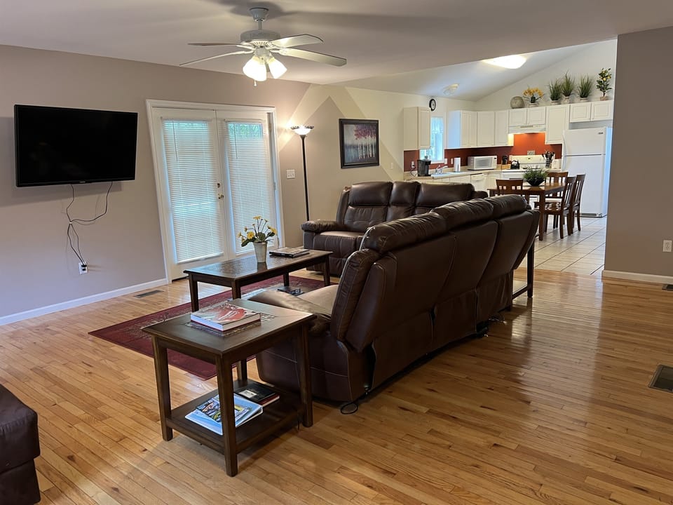 Apartment One living room with large smart TV and electric recliners.