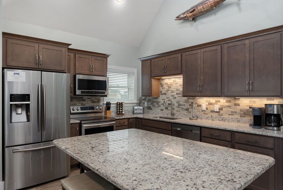 NH387C: Oak Island Cottage | Kitchen and Dining Area- Island Seating for 6
