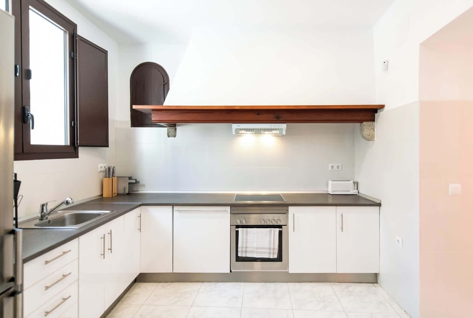 Bright kitchen featuring efficient layout and charming arched doorway detail