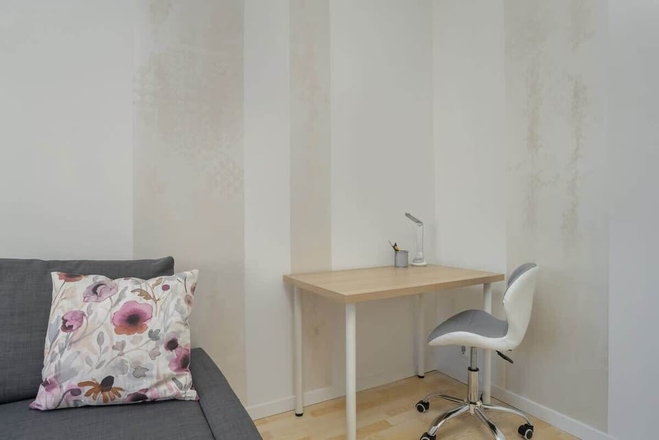 A study corner with a desk, chair, and patterned cushions, creating a functional workspace.
