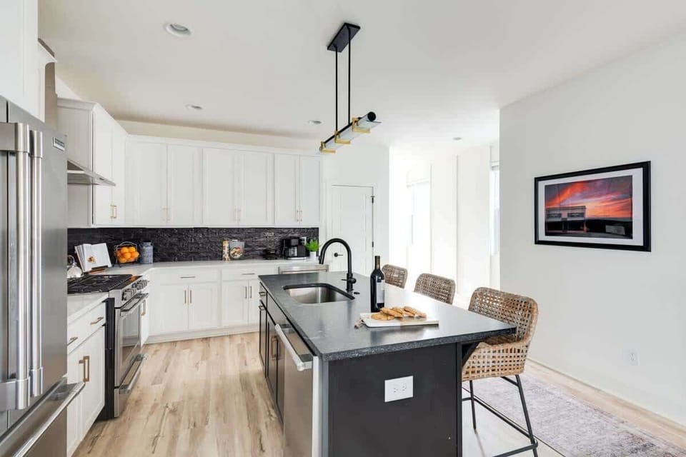 Clean and Spacious Kitchen with Sleek Countertops and Additional Seating