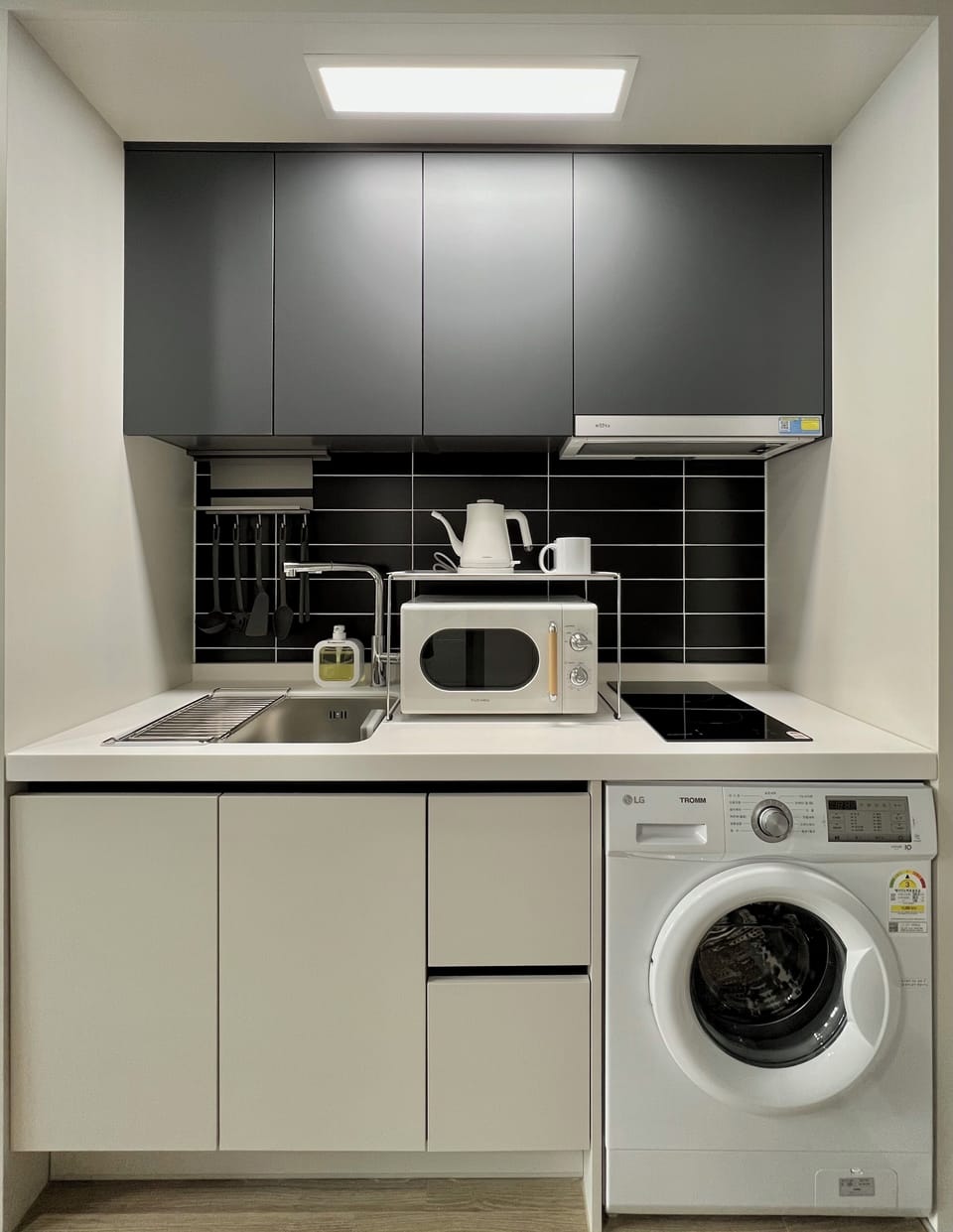 Full-size fridge, microwave, cookware/dishes/utensils, cleaning supplies