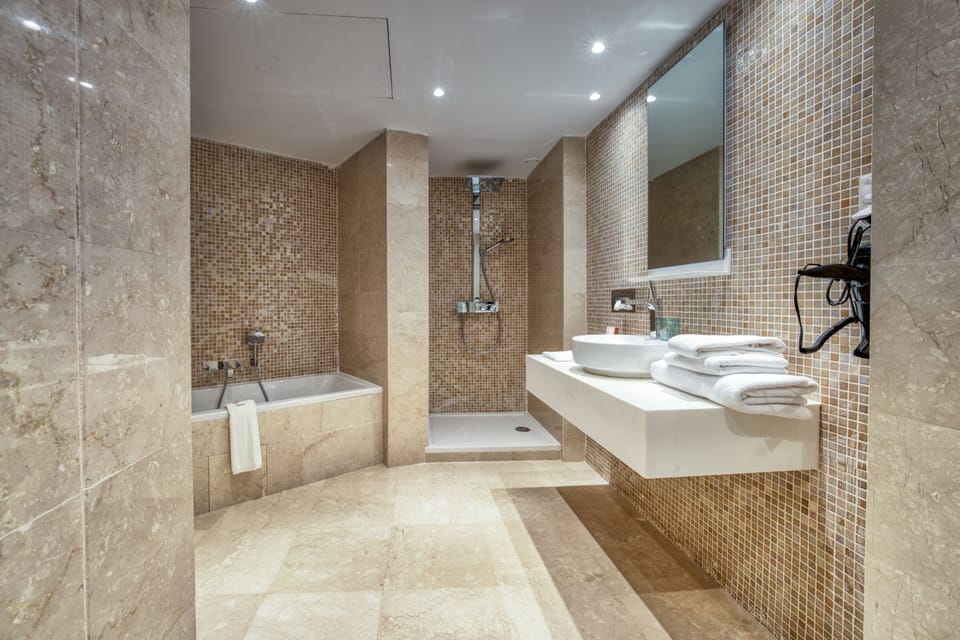Deep soaking tub, rainfall showerhead, designer toiletries, hair dryer