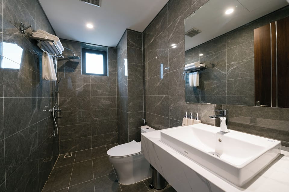 Deluxe Room | Bathroom | Hair dryer, slippers, bidet, towels
