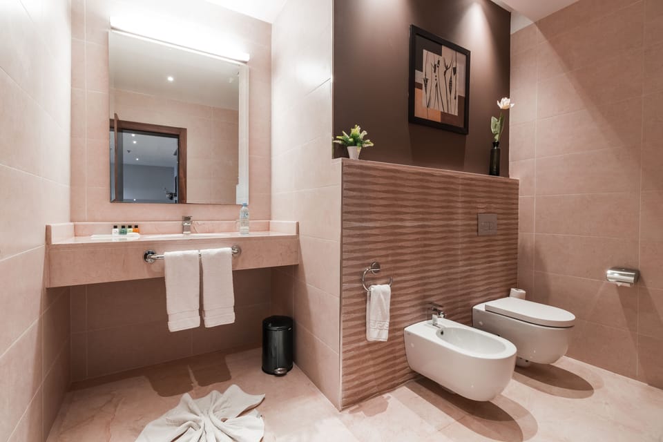 Bathtub, designer toiletries, hair dryer, bathrobes
