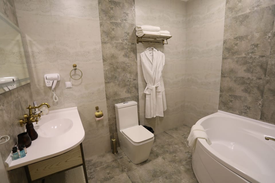Luxury Suite, City View | Bathroom | Rainfall showerhead, hair dryer, bathrobes, slippers