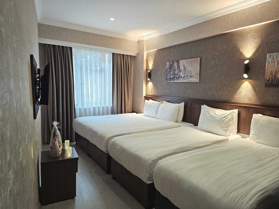 Deluxe Quadruple Room | Minibar, in-room safe, desk, laptop workspace
