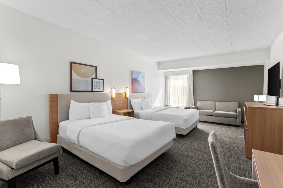 Premium bedding, desk, laptop workspace, blackout drapes