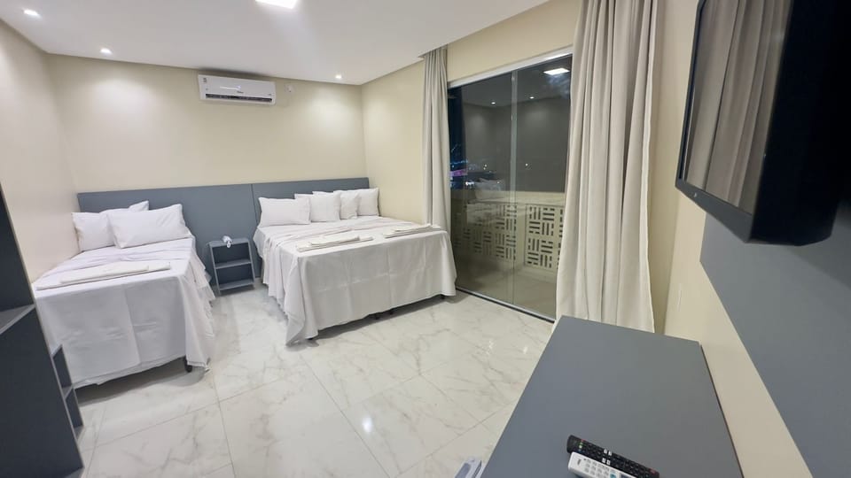 Deluxe Triple Room | Desk, laptop workspace, blackout drapes, iron/ironing board