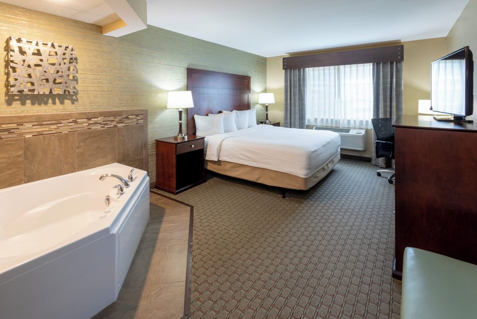 Room, 1 King Bed, Jetted Tub | Desk, iron/ironing board, free cribs/infant beds, free rollaway beds