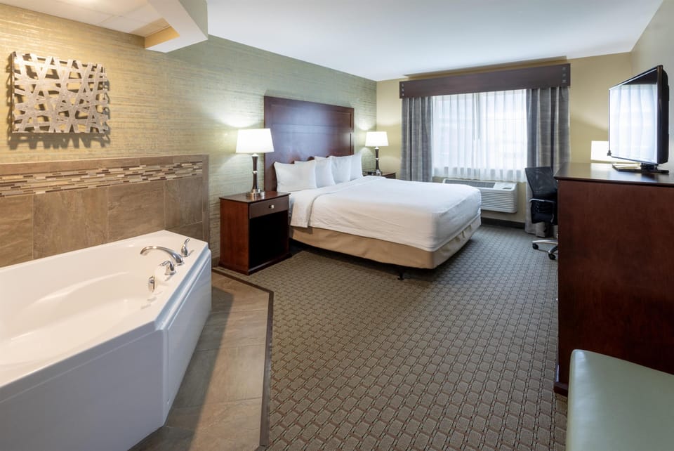 Room, 1 King Bed, Jetted Tub | Desk, iron/ironing board, free cribs/infant beds, free rollaway beds