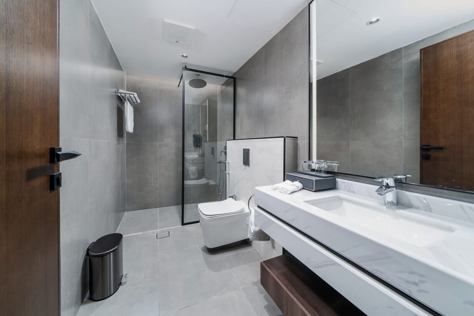 Deluxe Apartment | Bathroom | Hair dryer, bathrobes, slippers, towels