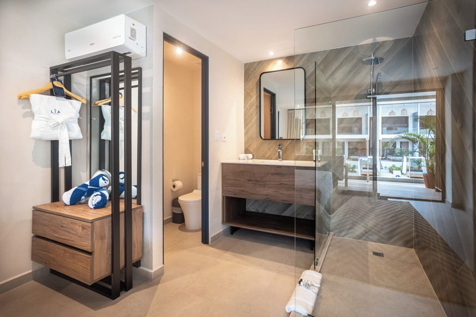 Deluxe Room, Pool View | Bathroom | Designer toiletries, slippers, towels, soap