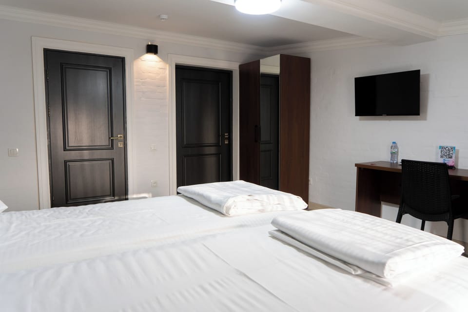 Family Triple Room, City View | In-room safe, desk, laptop workspace, blackout drapes