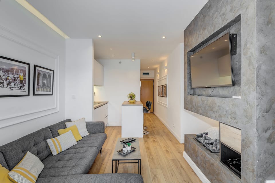 Deluxe Studio Suite, Balcony, City View | Living area | 100-cm flat-screen TV with cable channels