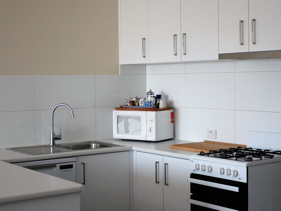 Deluxe 2 Bedroom Apartment, Upstairs | Private kitchen | Microwave, electric kettle, toaster, cleaning supplies
