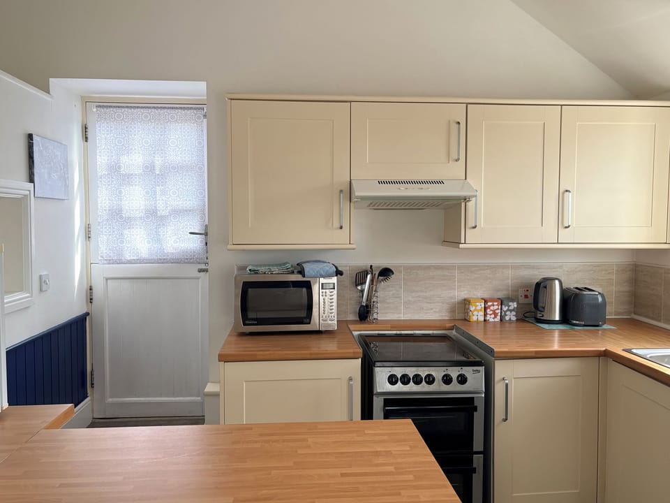 Cottage | Private kitchen | Fridge, electric kettle, toaster, cookware/dishes/utensils