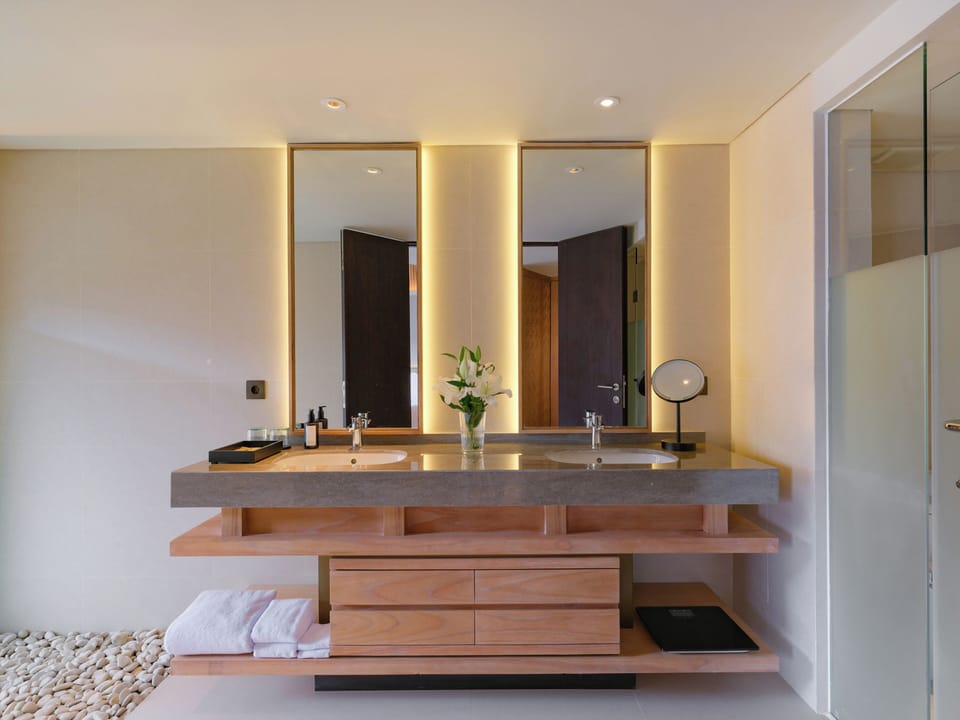 Grand Deluxe room, balcony and pool view - 1 king bed | Bathroom | Hair dryer, bathrobes, slippers, towels