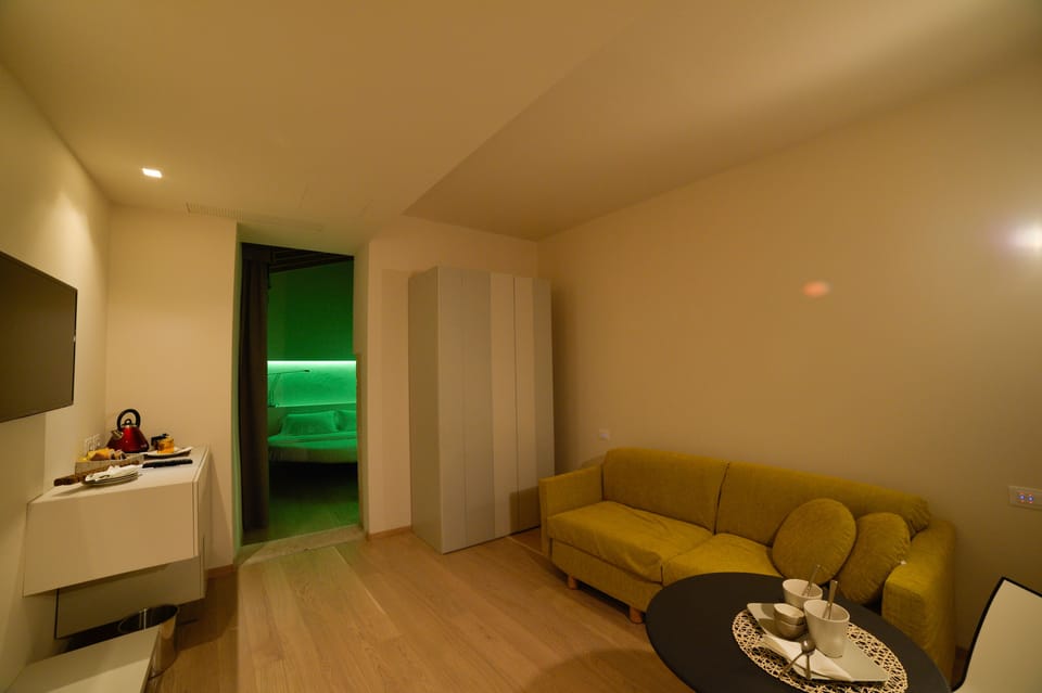 Design Quadruple Room, 1 Bedroom | Living area | Flat-screen TV