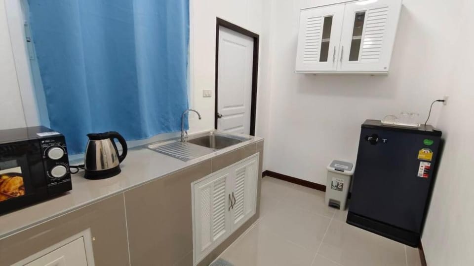 Fridge, electric kettle, cleaning supplies, paper towels