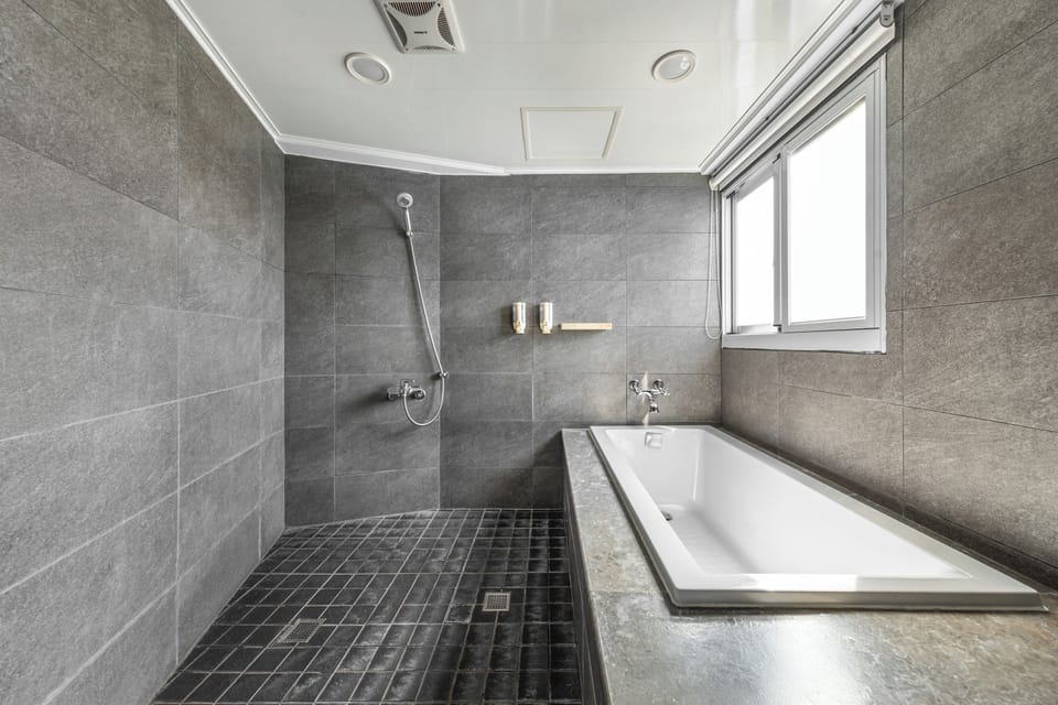 Deluxe Queen Room | Bathroom | Hair dryer, slippers, towels, shampoo
