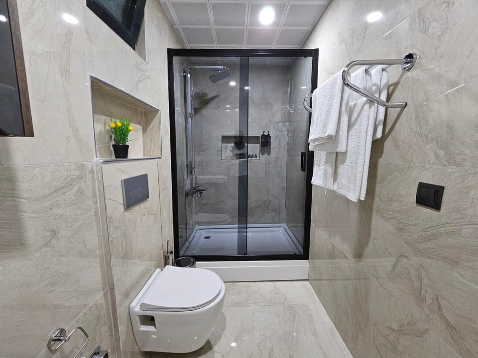 Deluxe Quadruple Room, Patio, City View | Bathroom | Shower, hair dryer, towels, soap