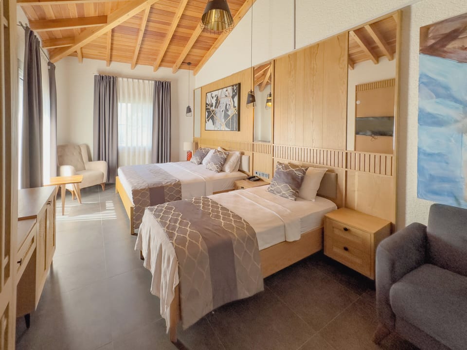 Deluxe Triple Room | Minibar, in-room safe, desk, laptop workspace
